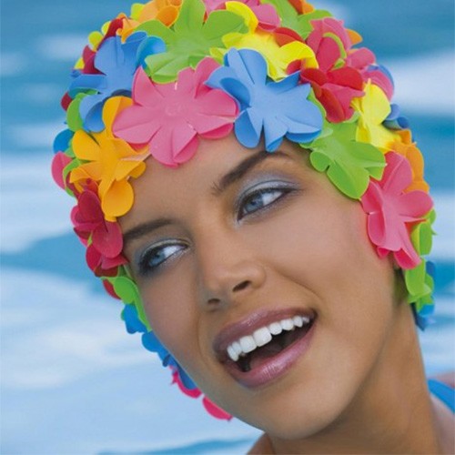 femme avec un bonnet de bain à fleurs qui rie dans une piscine Photos