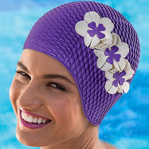 femme avec un bonnet de bain à fleurs qui rie dans une piscine Photos